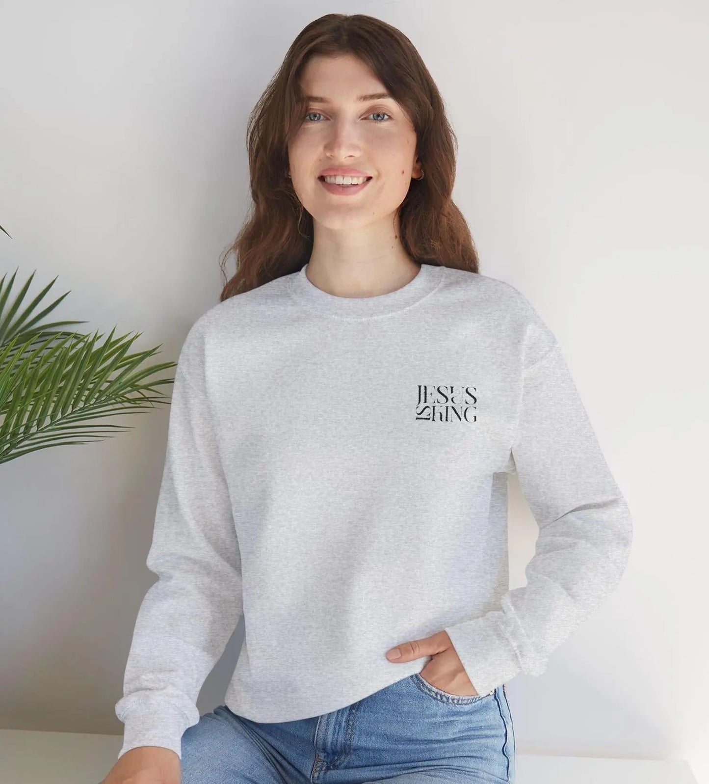 May include: A gray sweatshirt with the words 'JESUS KING' printed on the front in black.