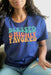 May include: A navy blue t-shirt with the text 'Blessed & Highly Favored' in rainbow colors. The text is in a retro font style. The text 'Luke 1:28' is printed in a smaller font below the main text.