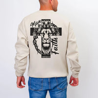 May include: Beige sweatshirt with a black graphic of a lion's head within a cross, with the words "Man of Faith" and "1 Corinthians 16:13". The sweatshirt has long sleeves and a crew neck.